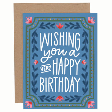 Pippi Post Very Happy Birthday greeting card with dark blue background, decorative floral border, white hand-lettered message, and kraft envelope