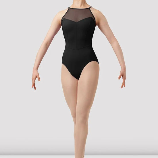 Adult dancer wearing black sweetheart halter leotard front view on pointe