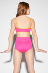 Back view of neon pink crossover dance trunks showing full coverage and high-waisted fit