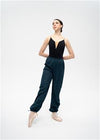 Adult dancer wearing black heat retention warm-up pants in a relaxed stance.