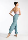 Adult dancer wearing light blue heat retention warm-up pants in a studio pose.