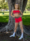 Young dancer wearing red cheetah-print dance shorts and matching cheetah-print top posing outdoors.