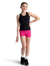 Full-body view of a child dancer wearing a black racerback tank top and pink shorts