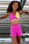 Dancer wearing a pink and yellow twist-style dance top with matching high-waisted shorts
