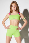 Dancer wearing a lime green dance top with V-shaped back and matching shorts