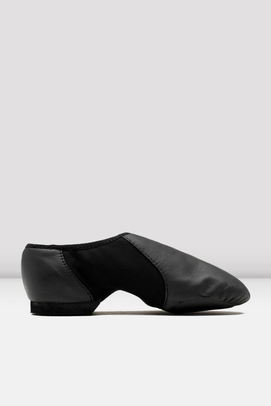 Side view of a black slip-on leather jazz shoe on a white background.